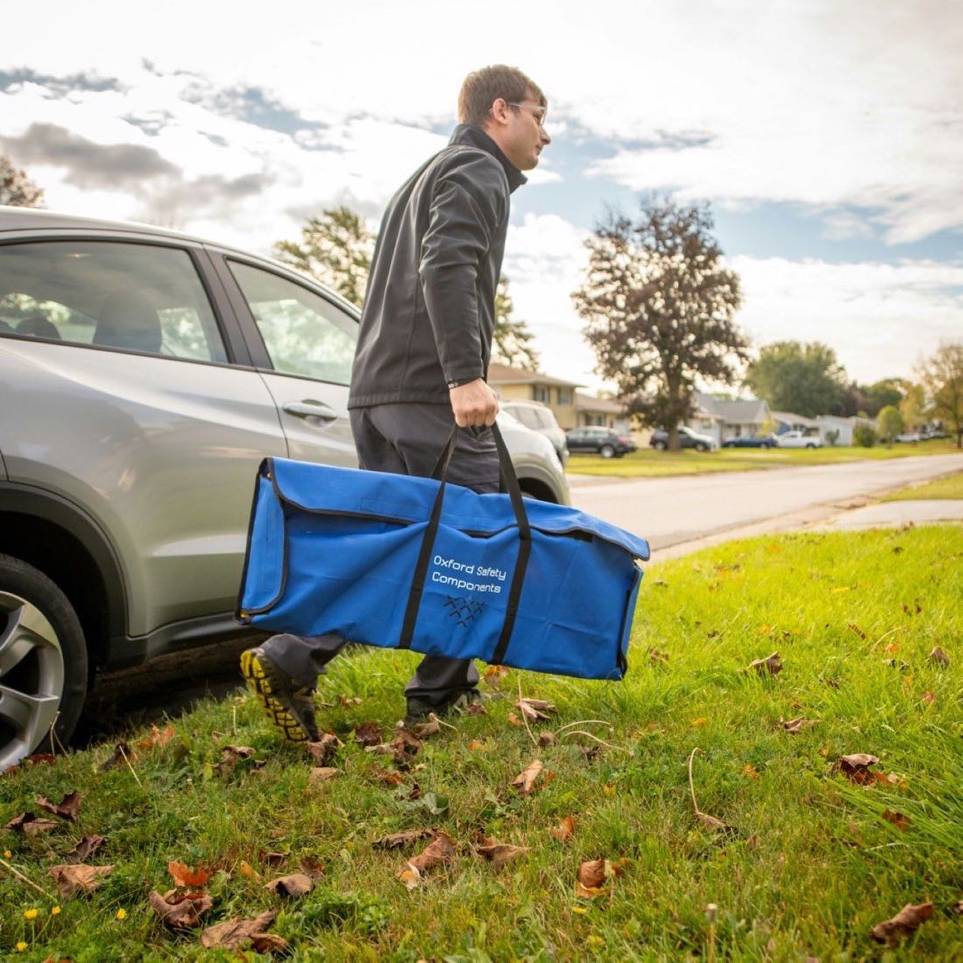 Service professional carrying a gear bag from his car to a customer's front door